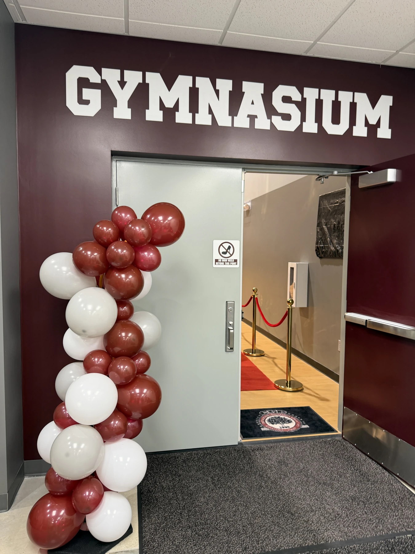 The competition gymnasium with the Mariners logo at center court and the stage at the far end