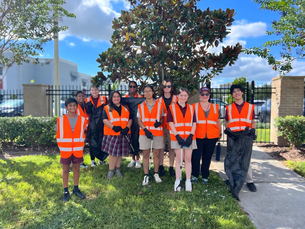 Central Florida Prep students in safety vests gather under a tree after a community service project
